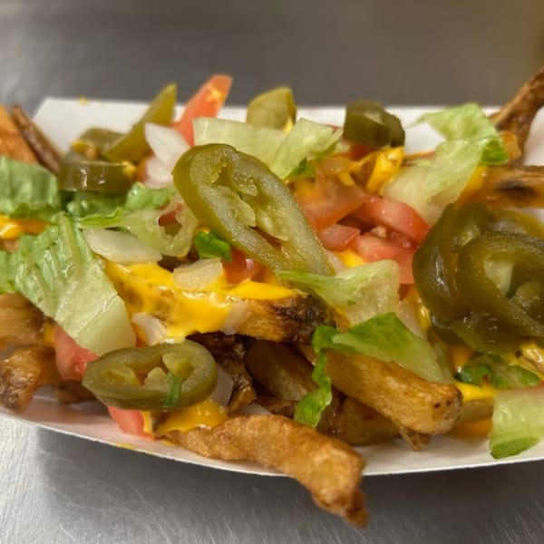 Doctor Dogs' loaded fries with melted cheese, jalapeños, lettuce, tomatoes, and onions.