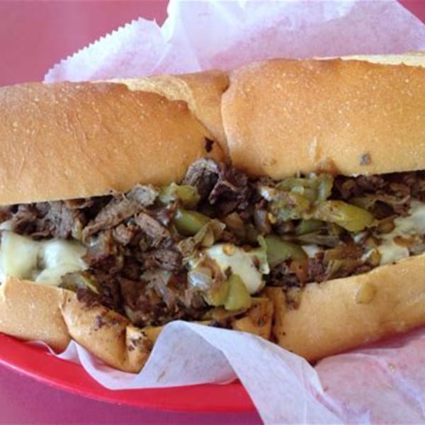 A Doctor Dogs cheesesteak with steak, melted cheese, and green peppers on a hoagie roll.