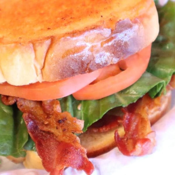 Close-up of a Doctor Dogs BLT sandwich with crispy bacon, lettuce, and tomato on toasted bread.